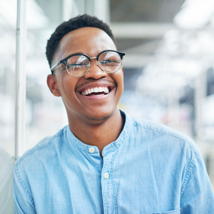 young man with glasses smiling